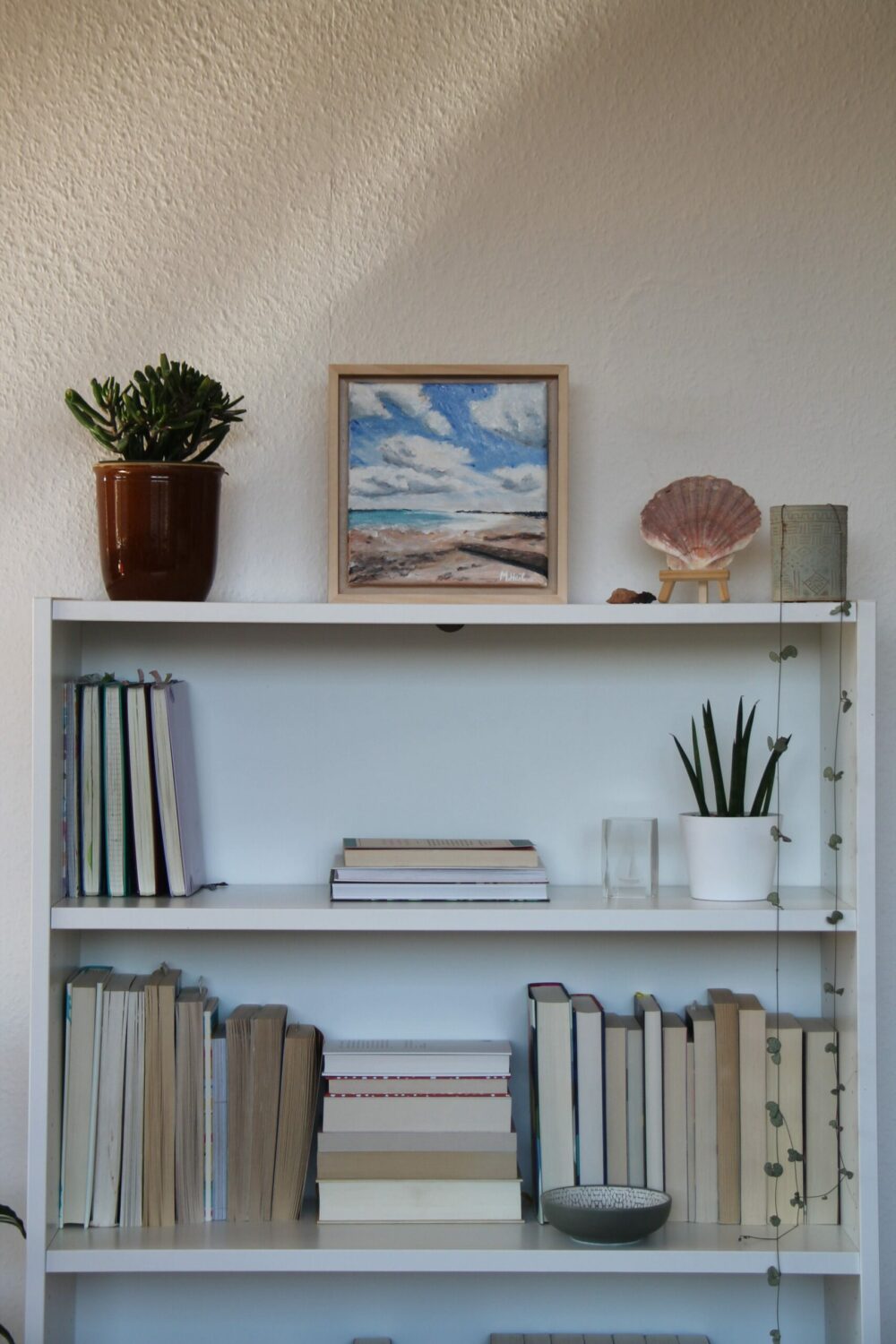 ocean view painting with books and shells