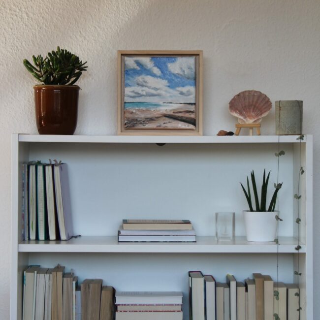 ocean view painting with books and shells