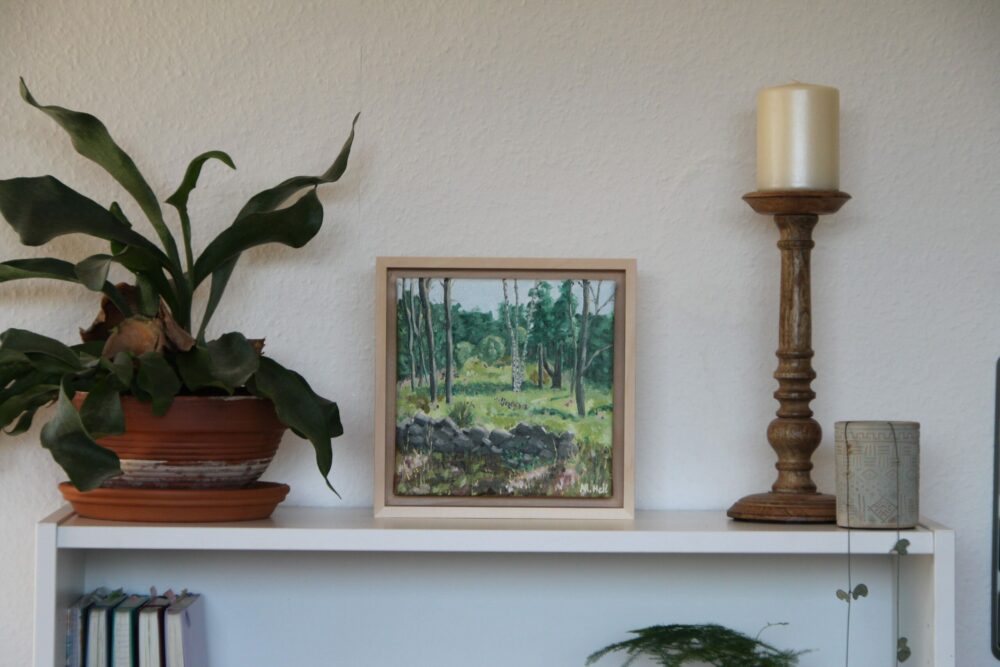 Forest glade painting on bookshelf